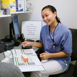 En kvinne som viser en mann noe på datamaskinen