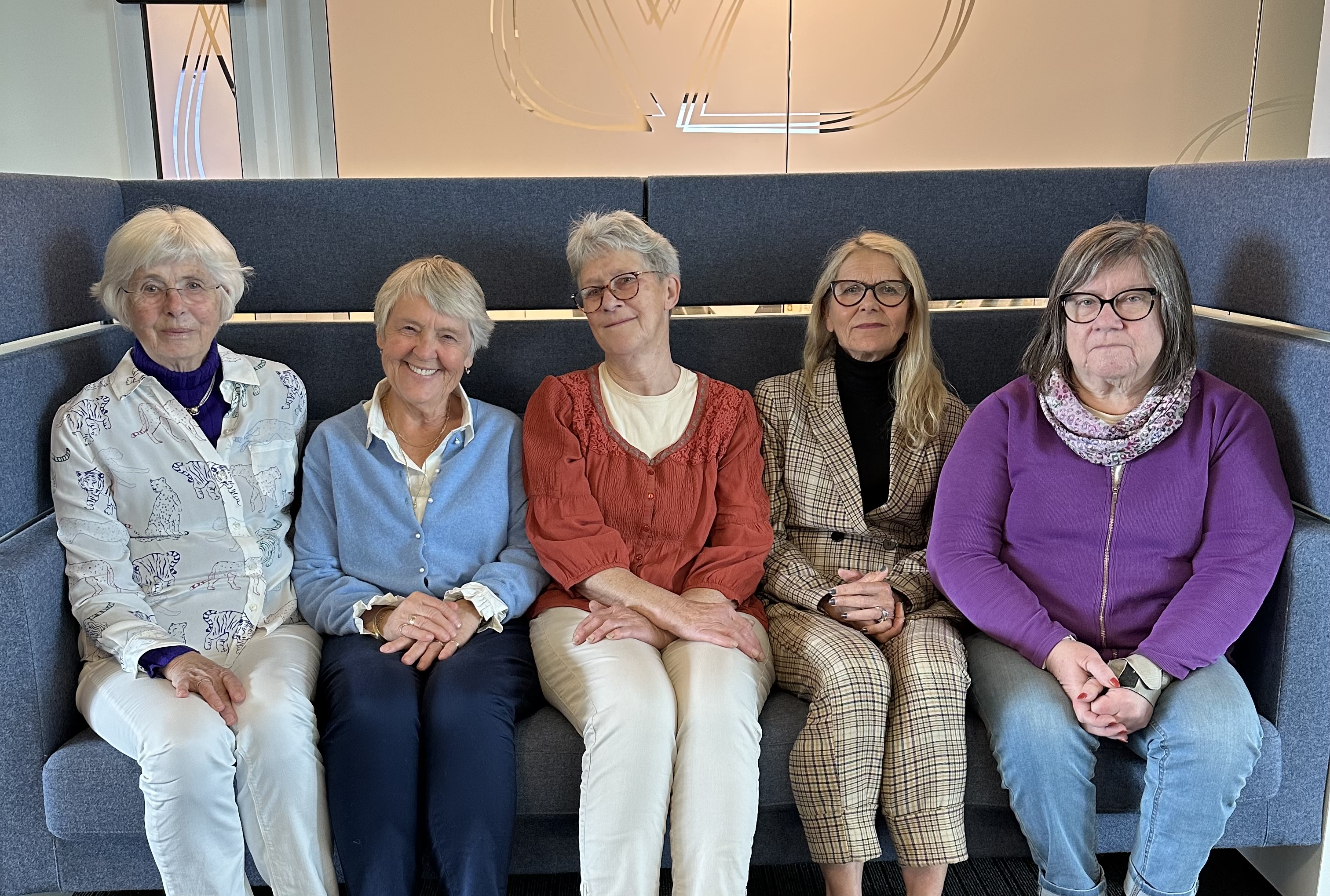 En gruppe kvinner som sitter på en benk