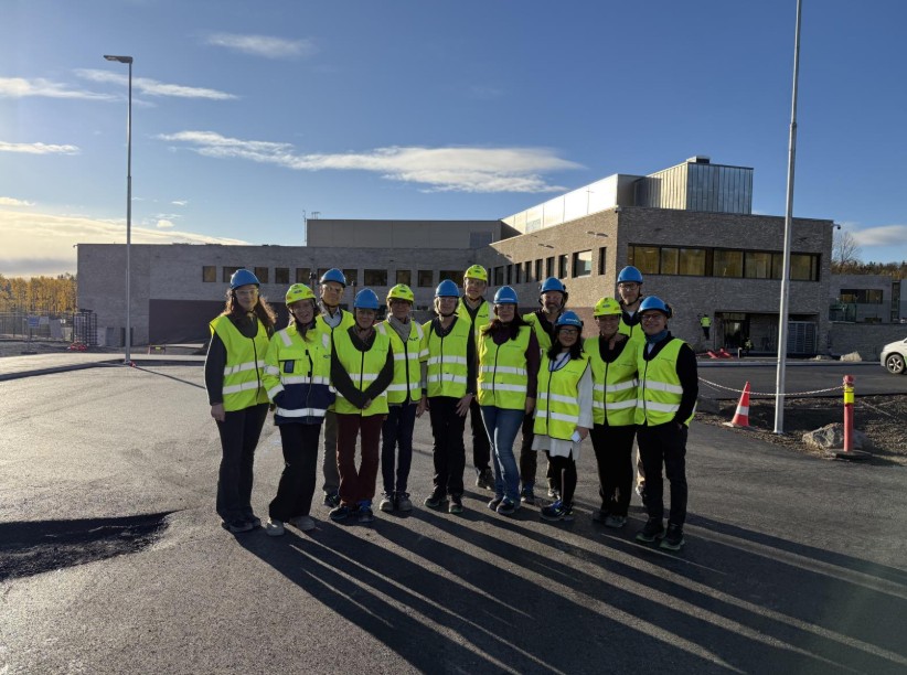 En gruppe mennesker i gule vester som står på en parkeringsplass